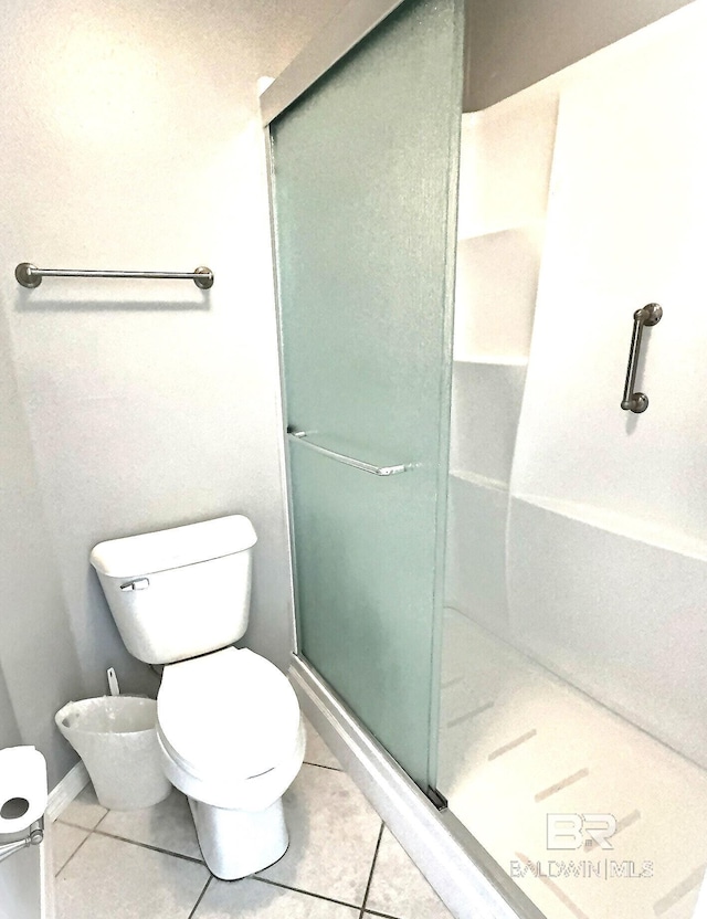 full bath with tile patterned flooring, toilet, and a stall shower