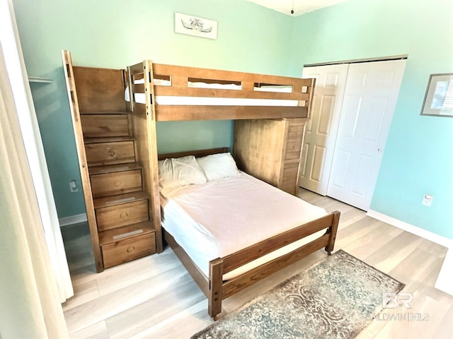 bedroom featuring a closet, baseboards, and wood finished floors