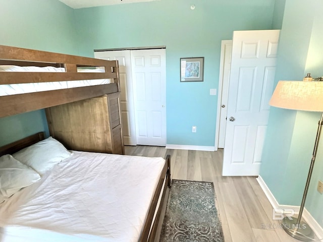 bedroom with a closet, baseboards, and wood finished floors