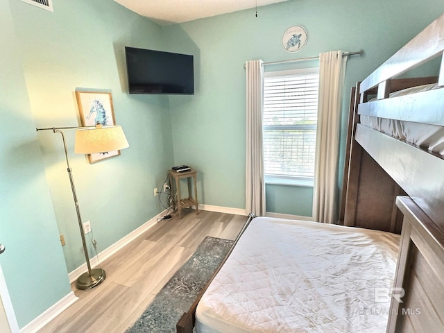 bedroom featuring wood finished floors and baseboards