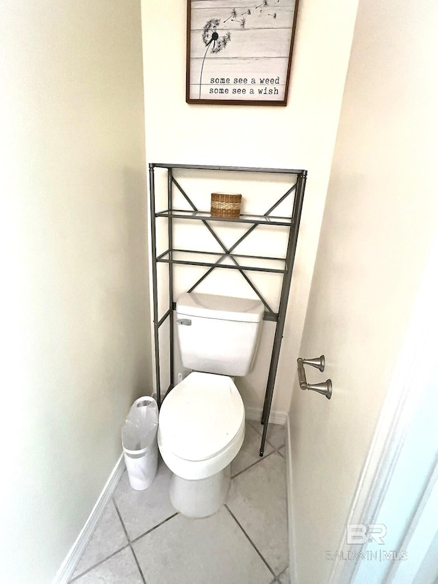 bathroom with tile patterned floors, toilet, and baseboards