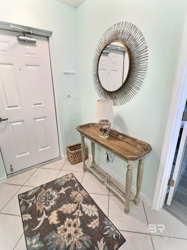 entryway with light tile patterned flooring and baseboards