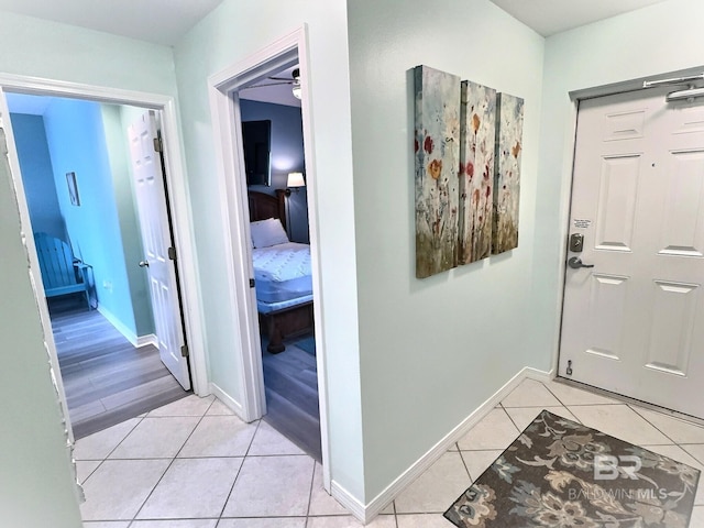 hall with light tile patterned floors and baseboards