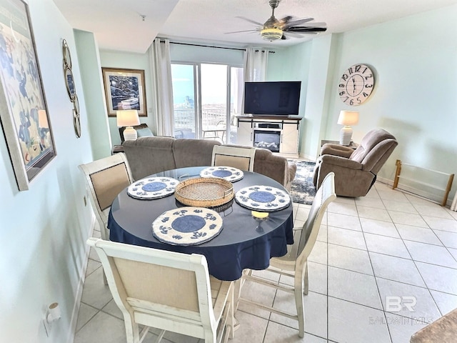 dining space featuring light tile patterned flooring, baseboards, and ceiling fan