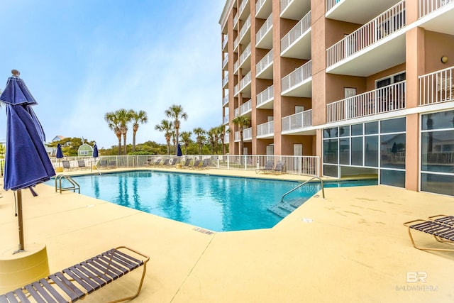 community pool featuring a patio area and fence