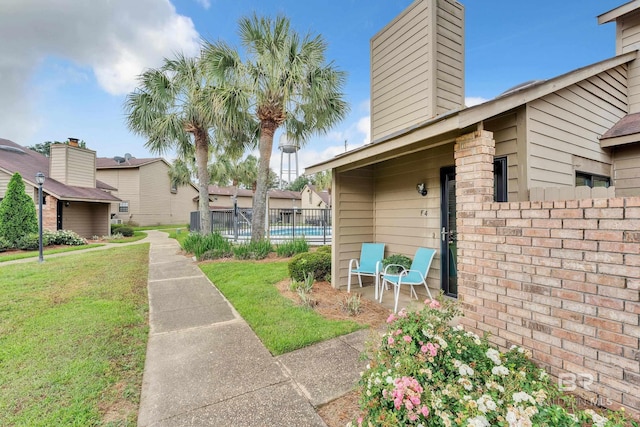 view of home's community with fence and a yard