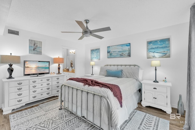 bedroom featuring baseboards, ceiling fan, light wood-style flooring, and visible vents