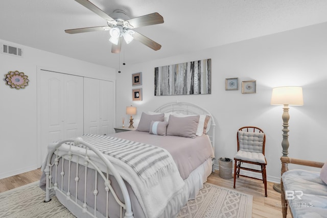 bedroom featuring light wood-style floors, visible vents, baseboards, and a closet