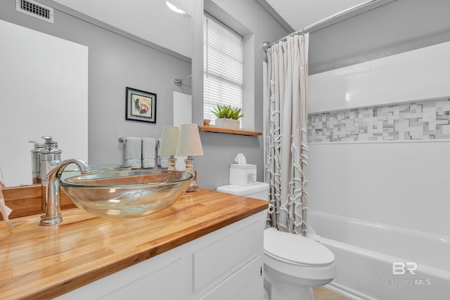 full bath with visible vents, shower / bathtub combination with curtain, toilet, and vanity