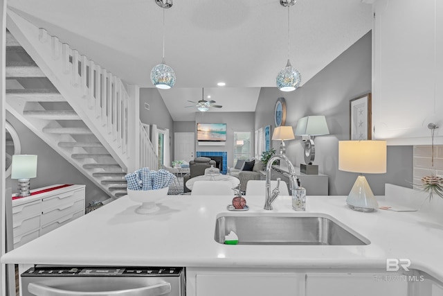 kitchen featuring white cabinets, ceiling fan, a sink, dishwasher, and vaulted ceiling