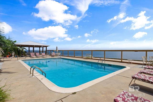 view of pool with a gazebo, a water view, and a patio