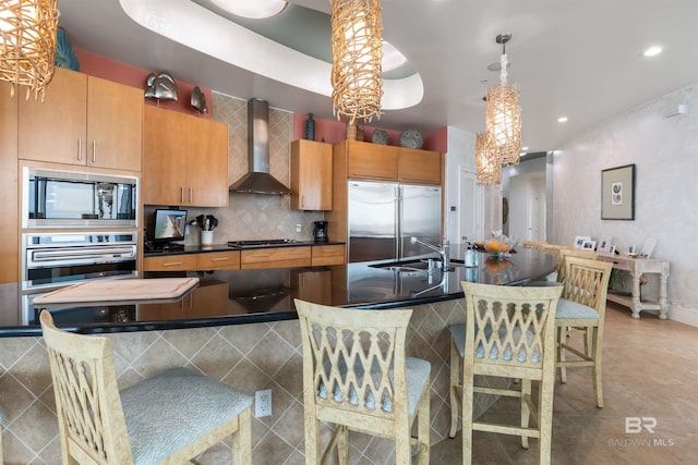 26302 Perdido Beach Blvd Unit D2201, Orange Beach, AL 36561 - kitchen featuring built in appliances, wall chimney range hood, a sink, dark countertops, and a center island with sink