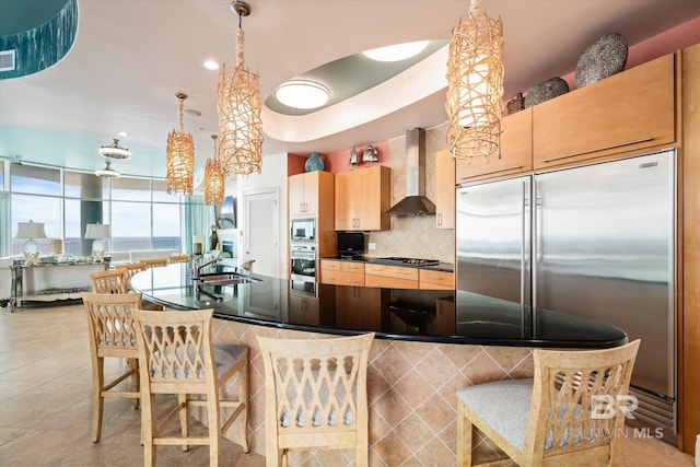26302 Perdido Beach Blvd Unit D2201, Orange Beach, AL 36561 - kitchen featuring wall chimney exhaust hood, built in appliances, a sink, dark countertops, and decorative backsplash