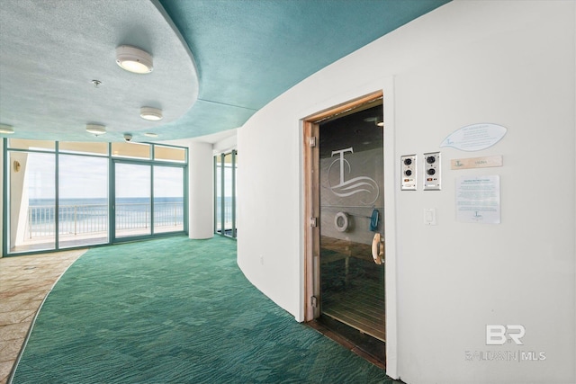 26302 Perdido Beach Blvd Unit D2201, Orange Beach, AL 36561 - corridor featuring a water view, a textured ceiling, carpet flooring, and a wall of windows