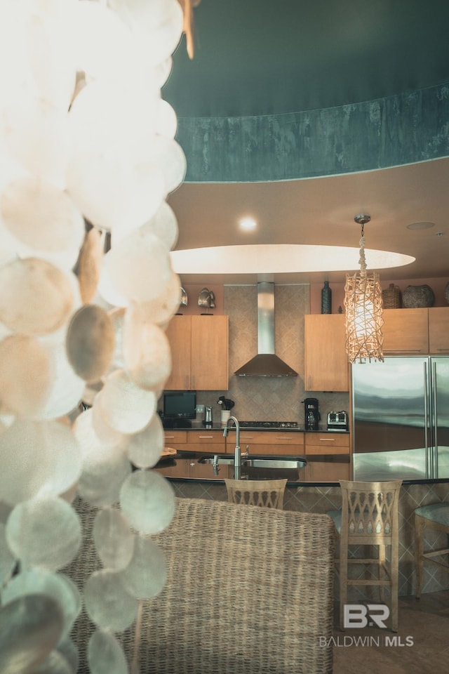 26302 Perdido Beach Blvd Unit D2201, Orange Beach, AL 36561 - kitchen featuring wall chimney exhaust hood, high end refrigerator, dark countertops, backsplash, and a sink