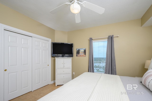 bedroom with ceiling fan, light hardwood / wood-style flooring, and a closet