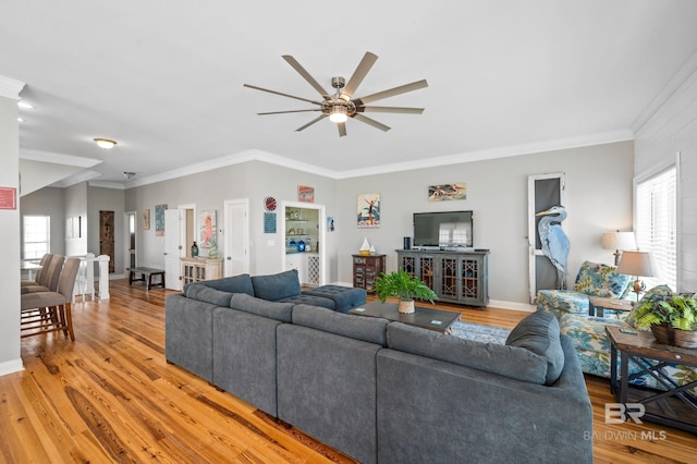 living room with hardwood / wood-style flooring, ceiling fan, and ornamental molding