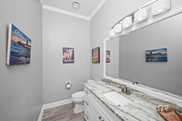 bathroom featuring wood-type flooring, vanity, toilet, and crown molding