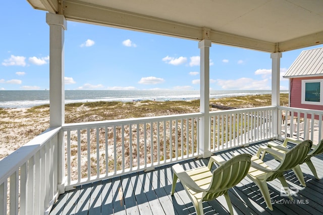 deck featuring a view of the beach and a water view