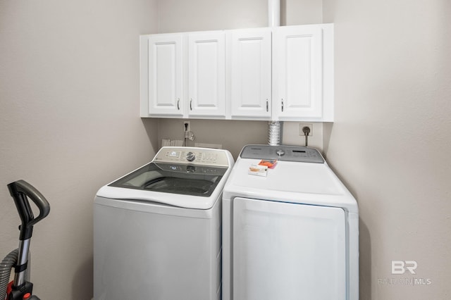 washroom featuring washing machine and dryer and cabinets