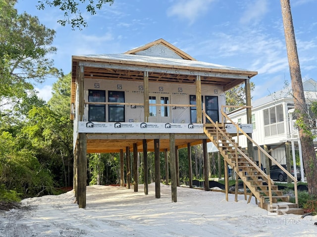 view of front facade featuring stairway, a carport, and a sunroom