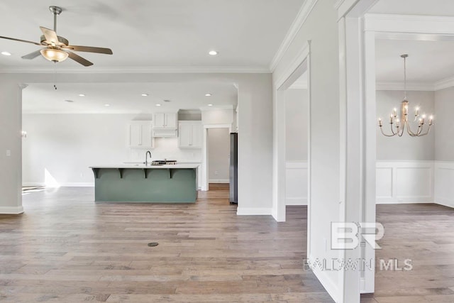 384 Garrison Blvd, Fairhope, AL 36532 - kitchen with a breakfast bar area, white cabinets, light countertops, ceiling fan, and light wood-style floors