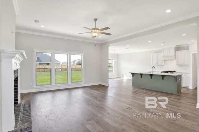 384 Garrison Blvd, Fairhope, AL 36532 - unfurnished living room featuring ceiling fan, a brick fireplace, dark wood-style flooring, recessed lighting, and ornamental molding