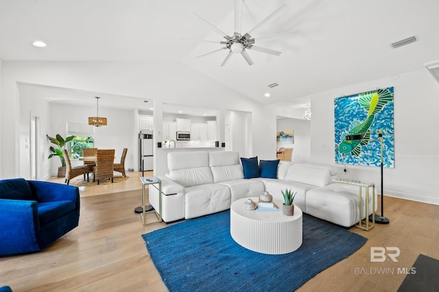 living room featuring vaulted ceiling, light hardwood / wood-style floors, and ceiling fan