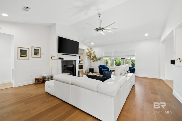 living room with high vaulted ceiling, ceiling fan, and light hardwood / wood-style floors