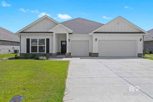 view of front facade with an attached garage, brick siding, driveway, a front lawn, and board and batten siding