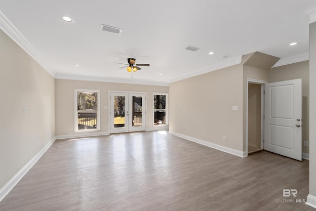 unfurnished living room with light wood-type flooring, visible vents, ornamental molding, and a ceiling fan