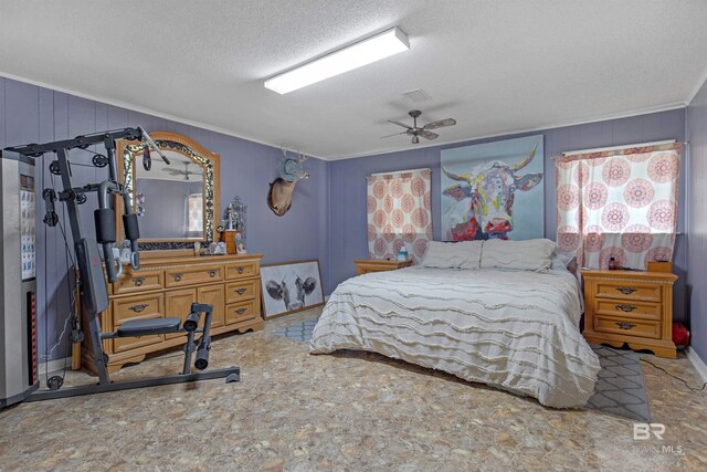 bedroom with a textured ceiling, connected bathroom, and wooden walls