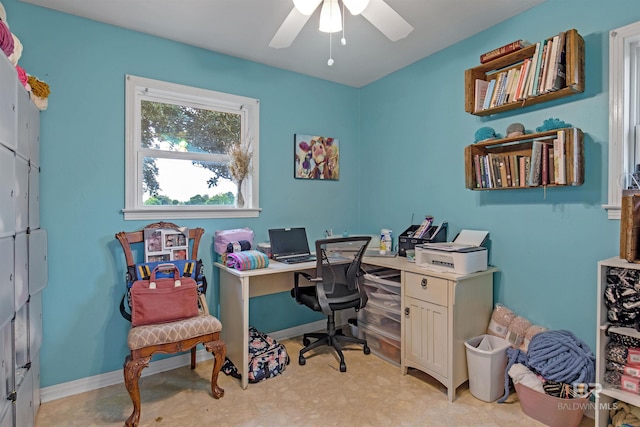 home office with a ceiling fan and baseboards