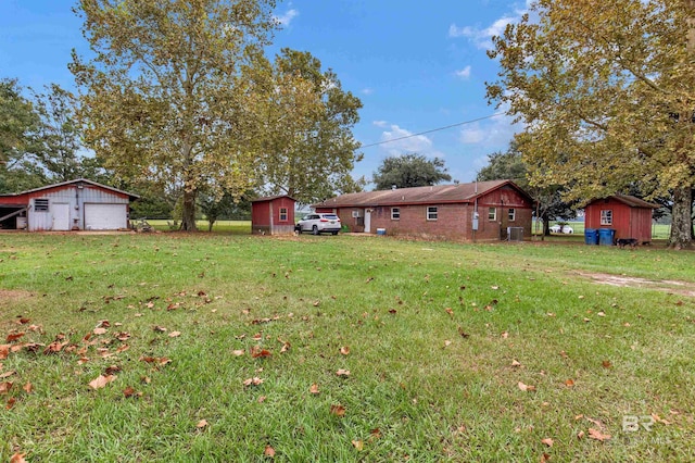 view of yard with an outbuilding, a storage shed, and a detached garage