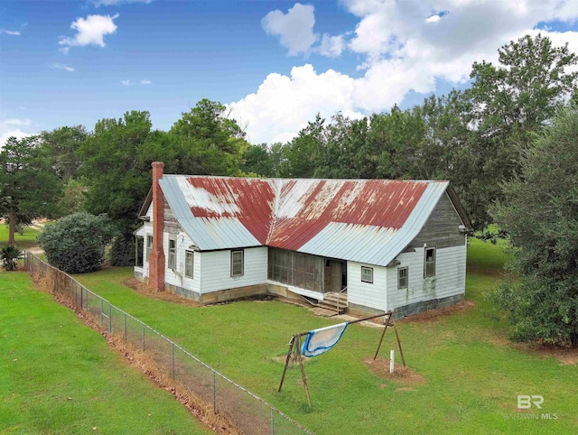 view of front of house featuring a front lawn, fence, and metal roof