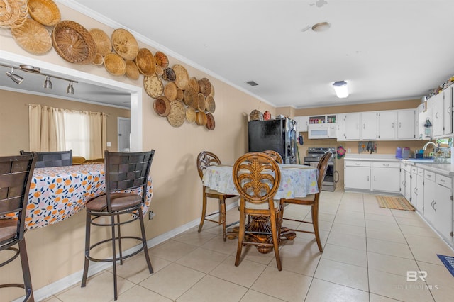 kitchen with ornamental molding, black fridge, stainless steel electric stove, light countertops, and white microwave
