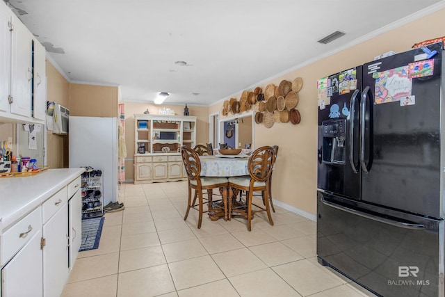 kitchen with black fridge with ice dispenser, light countertops, crown molding, and visible vents