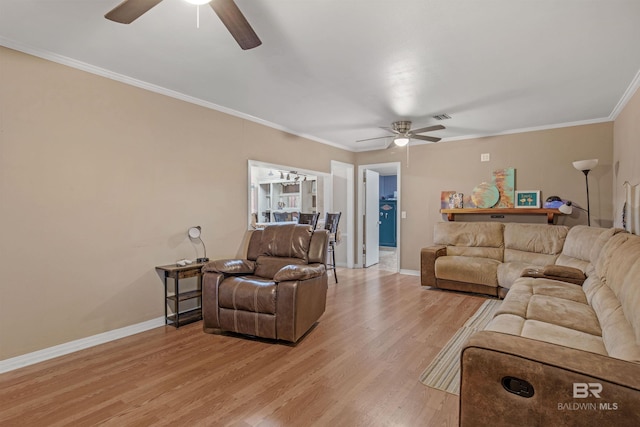 living area with crown molding, light wood-style flooring, a ceiling fan, and baseboards