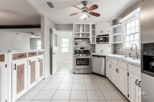 kitchen with tasteful backsplash, white cabinets, stainless steel appliances, ceiling fan, and sink