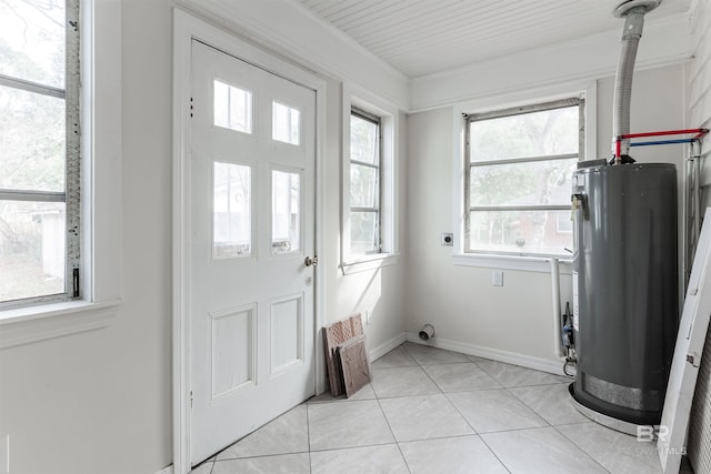 interior space featuring light tile floors, water heater, and a wealth of natural light