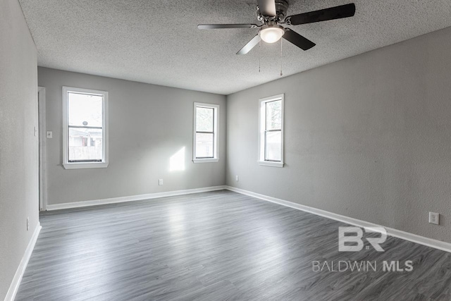 empty room with a textured ceiling, dark hardwood / wood-style floors, and ceiling fan