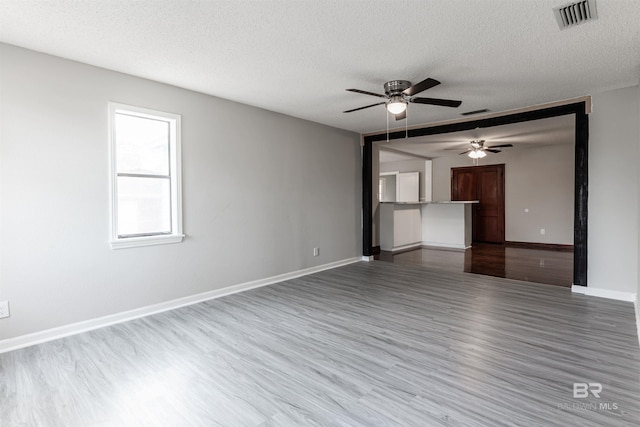 unfurnished room featuring ceiling fan, a textured ceiling, and dark wood-type flooring