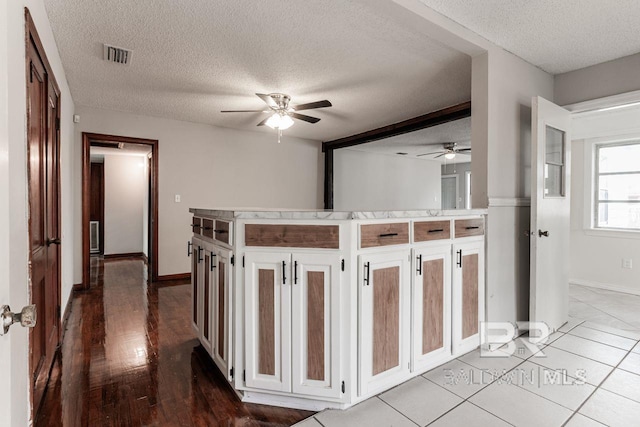 kitchen featuring a textured ceiling, light hardwood / wood-style floors, and ceiling fan