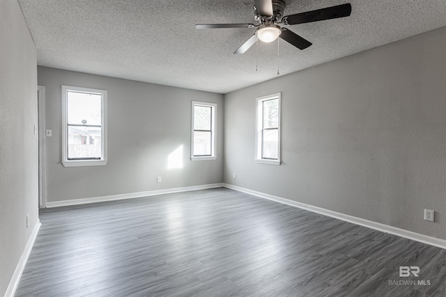 unfurnished room with ceiling fan, a textured ceiling, and dark hardwood / wood-style flooring