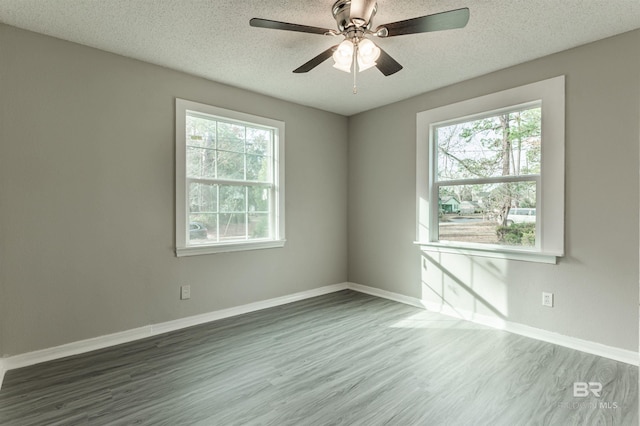 spare room with ceiling fan, a textured ceiling, and dark wood-type flooring