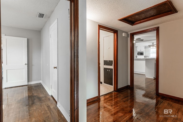 hall with dark hardwood / wood-style flooring and a textured ceiling