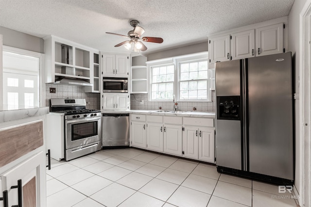 kitchen with light tile flooring, ceiling fan, tasteful backsplash, appliances with stainless steel finishes, and sink