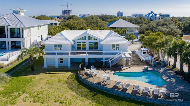 rear view of property featuring a fenced in pool, a yard, and a patio area