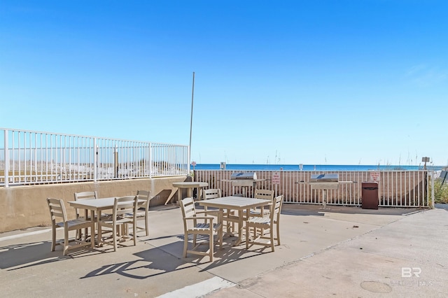 view of patio featuring a water view and outdoor dining space