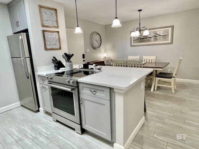 kitchen featuring light countertops, appliances with stainless steel finishes, wood tiled floor, and gray cabinetry